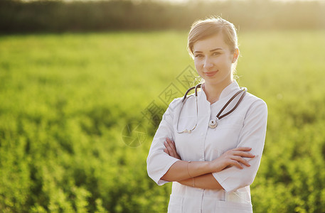 一位美丽的女医生或绿草背景护士的肖像和感染女性预防社工专家女士安全药品家庭医生医院背景图片
