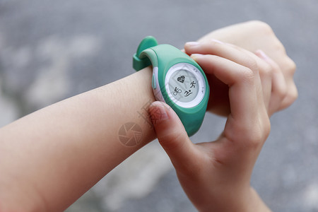 儿童定位手表女孩使用智能手表触摸按钮和触摸屏o工具检查数据展示活动界面技术运动赛跑者公园背景