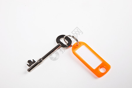 白背景上带有橙色键键环标记的密钥设备金属钥匙标签特写视图静物钥匙圈橙子影棚背景图片