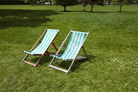 公园的两张甲板椅子季节座位绿色闲暇阳光花园传统条纹家具城市背景图片