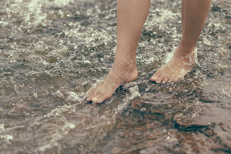 女人用水在河边石头上放轻松的腿池塘绿色治疗生活瀑布女士皮肤岩石蒸汽空气背景图片