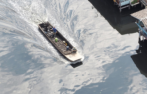小型和老旧的尾随船引擎鸟瞰图男人海洋海浪码头航行机器运输活动背景