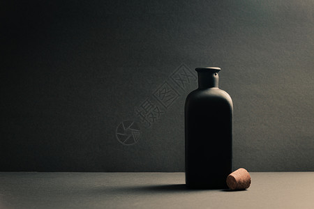单黑色瓷瓶 底底漆上插头特写的黑瓷瓶背景图片