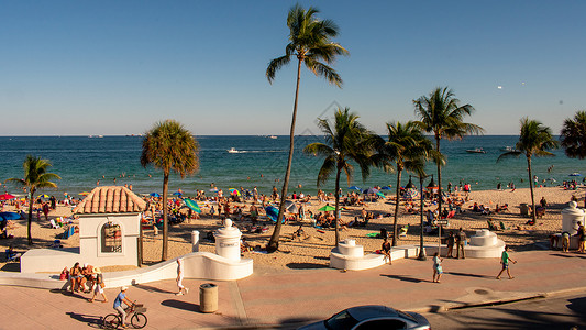 一片忙碌热带海滩景象的包头视图阳光海浪海景蓝天高架日落天空目的地假期棕榈背景图片