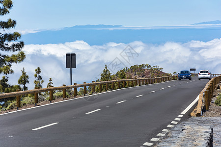 两辆汽车在山上公路上 高山边有浓云背景图片