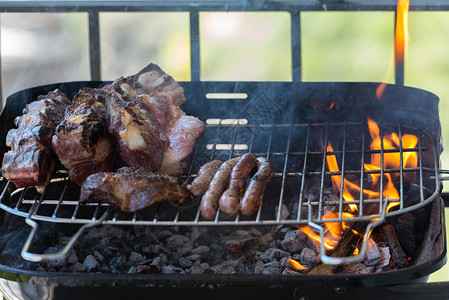 肋骨传统阿根廷和乌拉圭烧烤晚宴的近闭式烘烤文化食物香肠牛扒余烬火盆厨房美食盘子背景