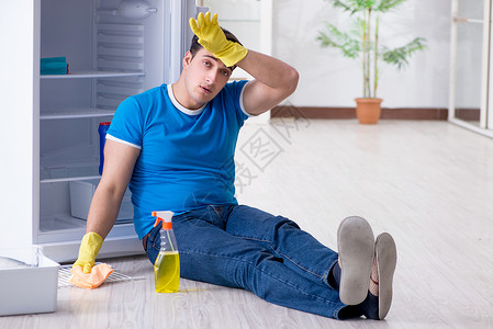 黄边冰箱在卫生概念中男人清洁冰箱管家食物丈夫灰尘服务厨房工作承包商海绵工人背景