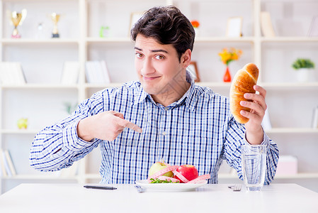 吃热狗人类在饮食中有健康食物和面包的两难境地水果热狗餐厅烹饪早餐午餐包子困境营养男人背景