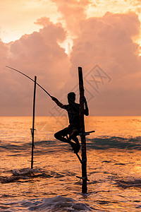 渔夫钓鱼斯里兰卡 Koggala 暴风雨中传统的斯里兰卡高跷渔民的剪影 高跷捕鱼是斯里兰卡岛国特有的一种捕鱼方式工作渔夫下雨支撑旅行太阳背景