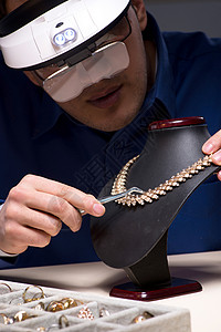 工作评价晚上深夜在车间工作的珠宝商工匠首饰戒指手镯玻璃估价师典当商维修男人镊子背景