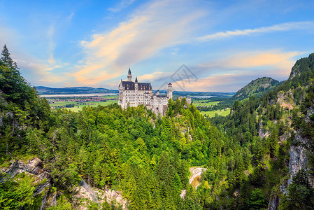 德国巴伐利亚西南部世界著名的纽施万斯坦城堡吸引力森林建筑日落童话全景旅行高山国王地标背景图片