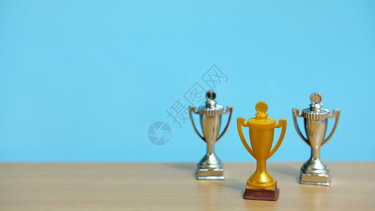 金奖杯 两银奖杯 在木制桌子上方胜利报酬团队蓝色数字商业冠军男性老板男人背景图片
