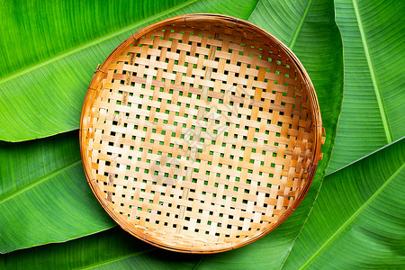竹空香蕉叶背景上的空木竹竹子篮子概念白色菜肴果汁食物团体家务餐厅琐事杯子背景