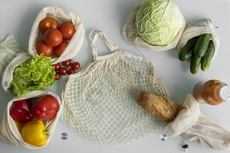 环保帆布购物袋 蔬菜 水果装在可重复使用的生态棉袋里 橙汁装在桌上的玻璃瓶里 零浪费购物理念 多次使用 再利用 回收店铺食物市场背景图片