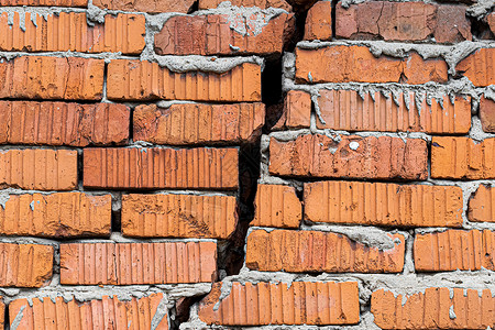 地震裂痕在一个红砖墙上背景