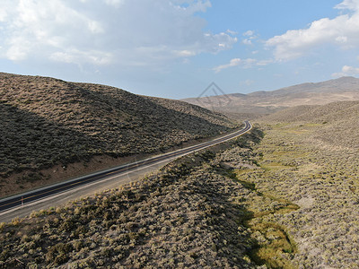 公路图在莫诺州绿色沙漠谷地中间的风景道路空中浏览图农田树梢山脉国家冒险假期森林娱乐鸟瞰图公路背景