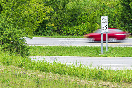 快速超速超过速度限制标志的红色赛车高清图片