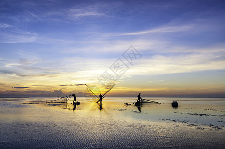 黑影渔民在清晨太阳日落天空橙子海滩钓鱼渔夫蓝色文化海洋背景图片