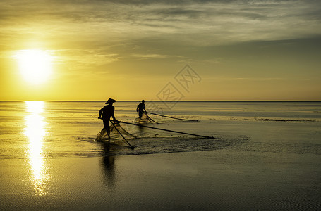 黑影渔民在清晨反射海洋钓鱼日落海滩旅行天空蓝色橙子文化背景图片
