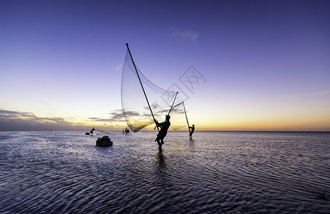 黑影渔民在清晨文化渔夫钓鱼海洋太阳海滩天空日落橙子反射背景图片