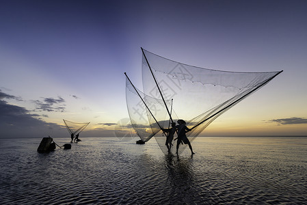 黑影渔民在清晨海洋渔夫天空钓鱼橙子太阳蓝色旅行日落海滩背景图片