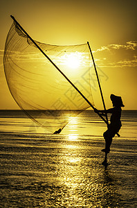 黑影渔民在清晨海滩渔夫钓鱼海洋反射天空太阳橙子日落旅行背景图片