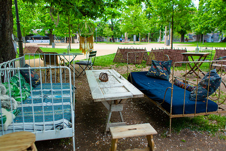床桌绿色公园中的时装咖啡厅 家具和门外的露天桌背景
