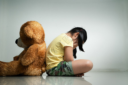 带泰迪熊的小姑娘坐在空房的地板上光谱女孩自闭症生长药品症状概念孤独社会心理学背景
