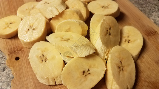 砍柴板上切片白瓜香蕉午餐车前草食物砧板小吃芭蕉木板木头黄色背景图片