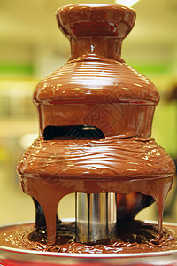 黑色巧克力喷泉甜点人类甜食牛奶宏观黄色饮食奢华婚礼棕色背景图片