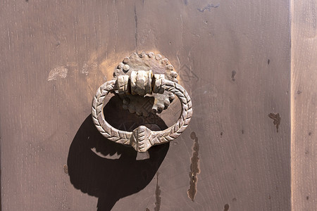 木门上带有装饰元素的金属把手建筑衣柜木板房子木头贮存门把手配饰古董金子背景