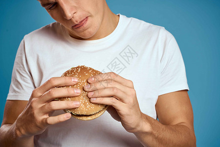 有汉堡和白色T恤 蓝色背景情感的人 用双手探探究 复制空间CopySpace餐厅饮食肥胖胡子男生午餐工人芝士脂肪男性背景图片