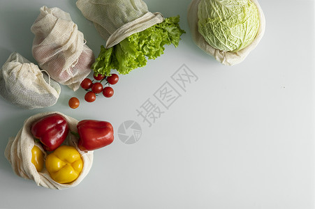桌上可重复使用的生态棉袋中的蔬菜 水果 鸡蛋 零浪费购物理念 无塑料物品 多次使用 再利用 回收 带西红柿 胡椒 面包的环保帆布背景图片