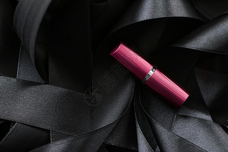 黑色丝绸背景的粉红口红 奢华化妆和美容皮革静物女士化妆品光泽度粉色魅力背景图片