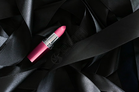 黑色丝绸背景的粉红口红 奢华化妆和美容光泽度静物化妆品皮革粉色女士魅力背景图片