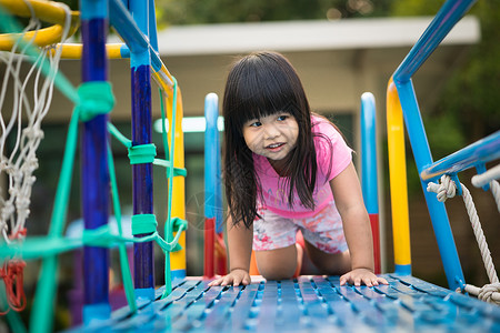 亚裔小女孩喜欢在儿童游乐场玩耍操场孩子们娱乐幼儿园孩子城堡女孩青年童年享受背景图片