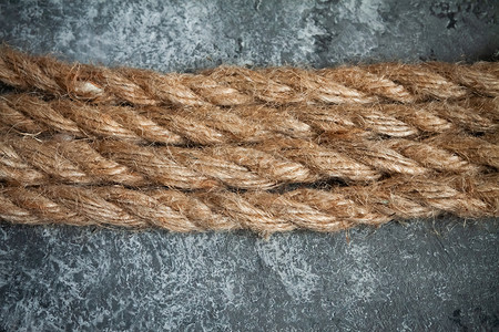 灰色混凝土背景上的黄麻绳力量工具黄麻螺旋材料褐色绳索海洋电缆蕾丝背景图片