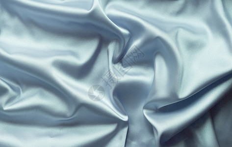 平滑优雅的蓝色丝绸和柔软折叠可用作背景概念材料纺织品折痕衣服图像布料织物投标海浪背景图片