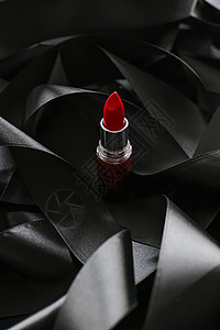 黑色丝绸背景的红口红 奢华化妆和美容光泽度魅力化妆品静物皮革红色女士背景图片