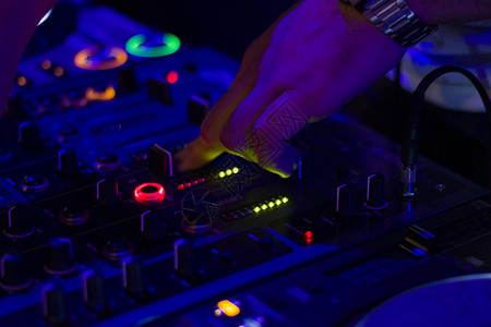 DJ 控制器和 DJ 手 播放音乐场景 彩色灯光乐器背景 混音器和音乐混合职业男人享受硬件气氛夜店甲板夜生活庆典提示背景图片