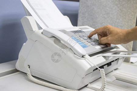 帮手在办公室里用传真机 装有设备影印命令男人电话工人复印机传真秘书服务扫描器背景图片