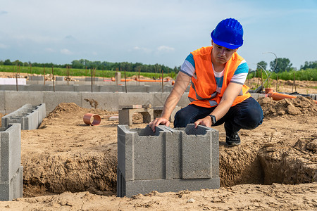 一位年轻的建筑工程师用丢失的模板为一栋建筑打地基图片