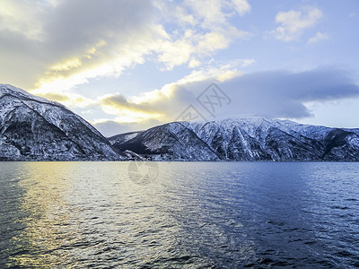 挪威索格涅夫湾的冬季风景和清晨日出时间阳光反射海岸金子日落太阳夕阳山脉天空背景图片