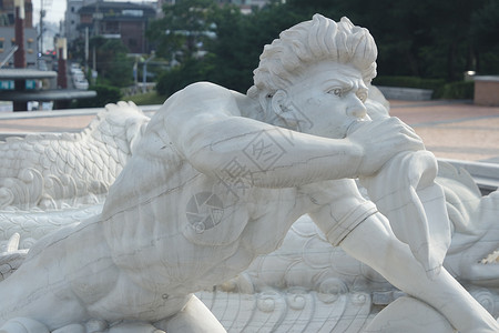 童话沙雕Triton的石头雕塑 吹在他的海螺贝壳小号上人鱼气氛海卫喇叭风格艺术品大理石建筑学艺术白色背景