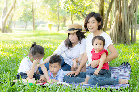 美丽的年轻年幼的亚洲家庭家长肖像 在公园野餐母亲成人父母孩子女性福利活动花园乐趣女士背景图片
