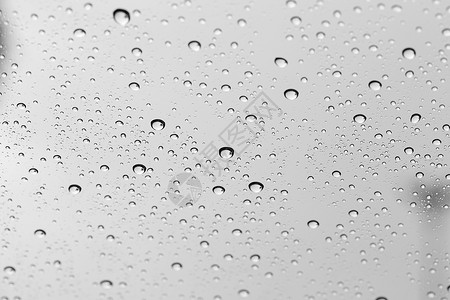 玻璃镜背景上的水滴下雨玻璃屏幕白色天空交通天气反射黑色驾驶图片