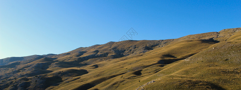 波斯尼亚语横幅 日落前秋天的山 山 草地 牧场 草地 石头 天空的景观 简单但壮丽的景观背景