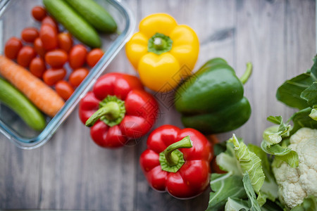 木制桌上的鲜鲜彩明亮的胡椒和其他蔬菜绿色菜花饮食黄色沙拉营养团体西红柿食物萝卜背景图片