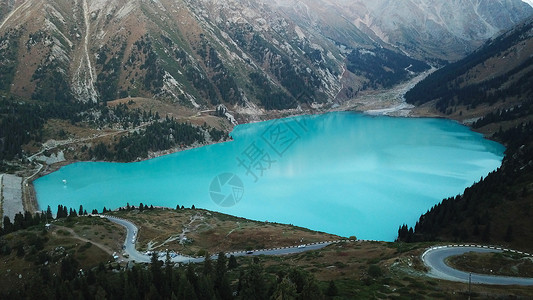 巴音州风景大阿拉木图湖在山上 绿山森林树木山脉力量蓝色旅游季节花朵岩石国家背景