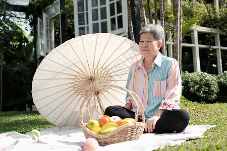 在花园野餐的年长老老女人 年纪大了食物女士公园老年野餐花园娱乐退休闲暇背景图片